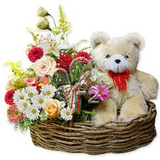 Teddy sittng in a mix flowers basket